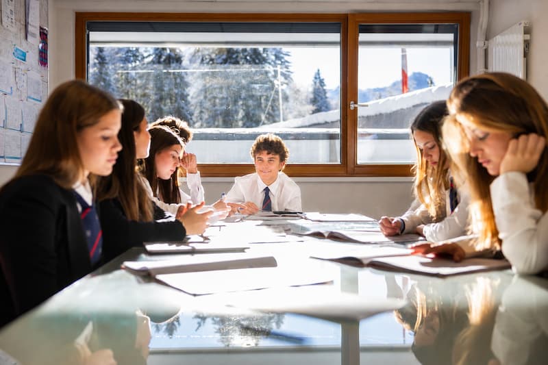High School students learning together around a Harkness table at Chalet Le Roc.