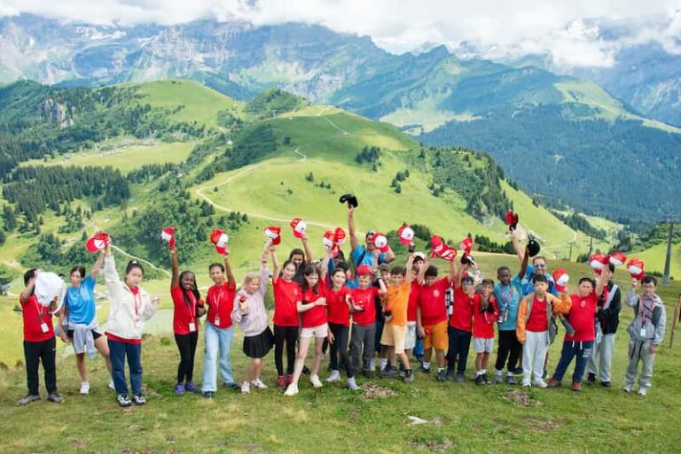Children celebrating at La Garenne Summer Camp with panoramic Swiss mountain views in the background