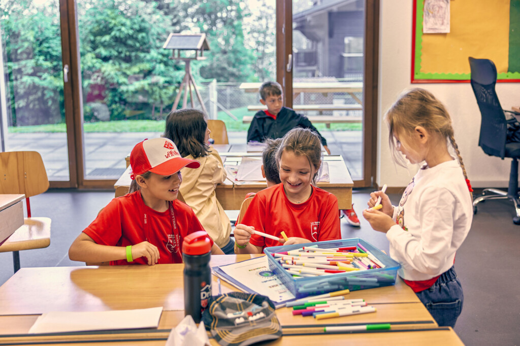 Children taking part in a creative French language classroom activity during the French Language Summer Camp at La Garenne International School in Switzerland.