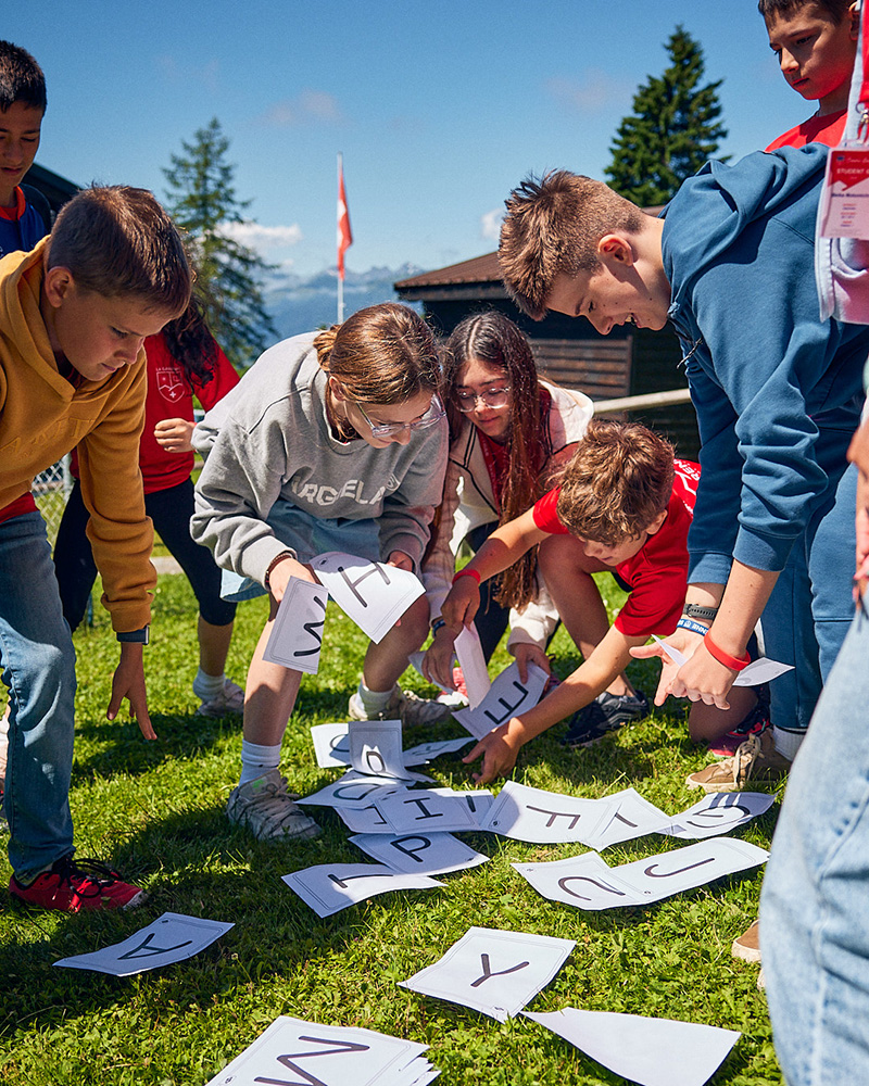 Students participating in an interactive outdoor French language learning activity during the French Language Summer Camp at La Garenne International School in the Swiss Alps.