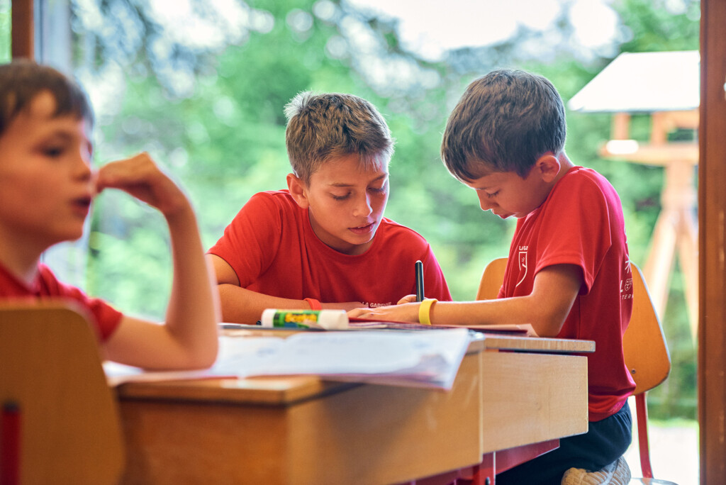 Students developing their French language skills through collaborative classroom activities during the French Language Summer Camp at La Garenne International School in Switzerland.