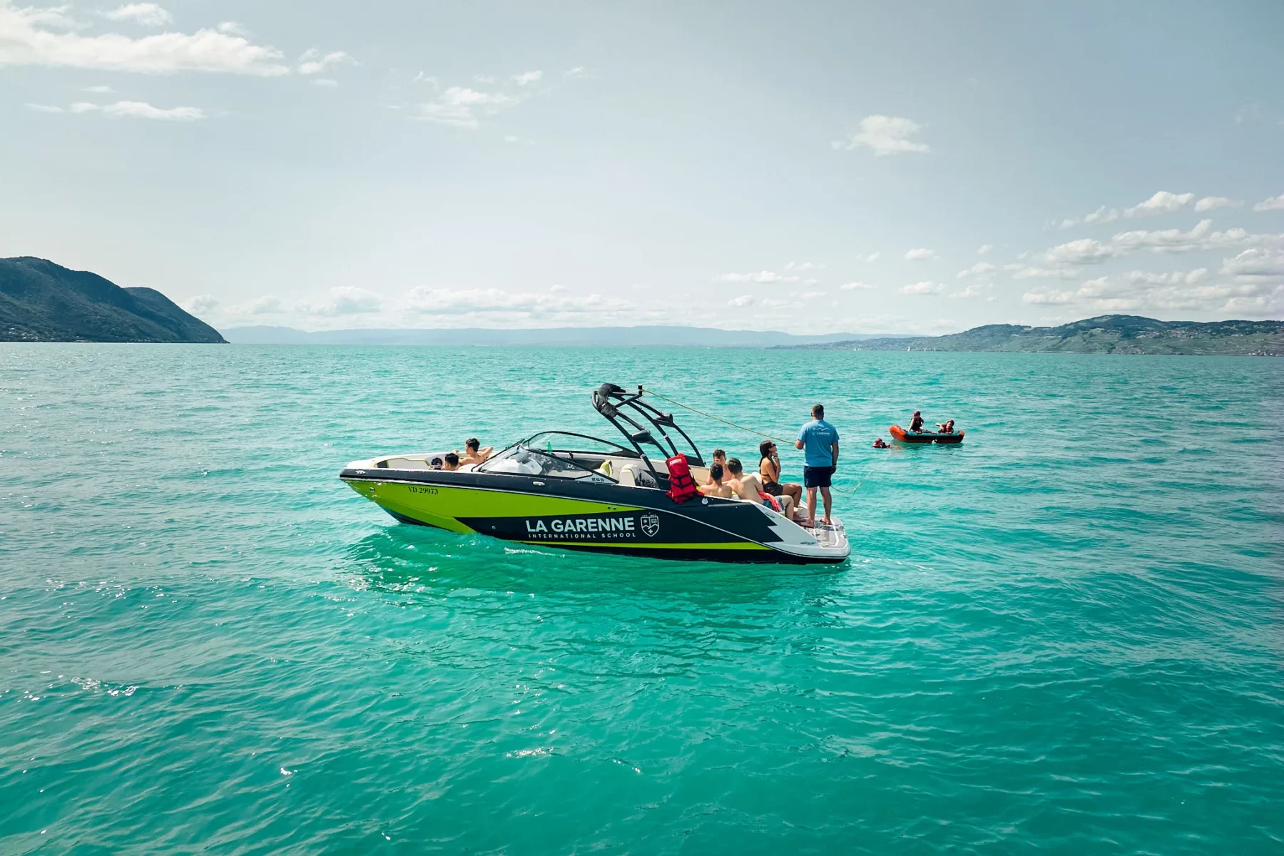 Summer campers on a La Garenne speedboat on the turquoise lake